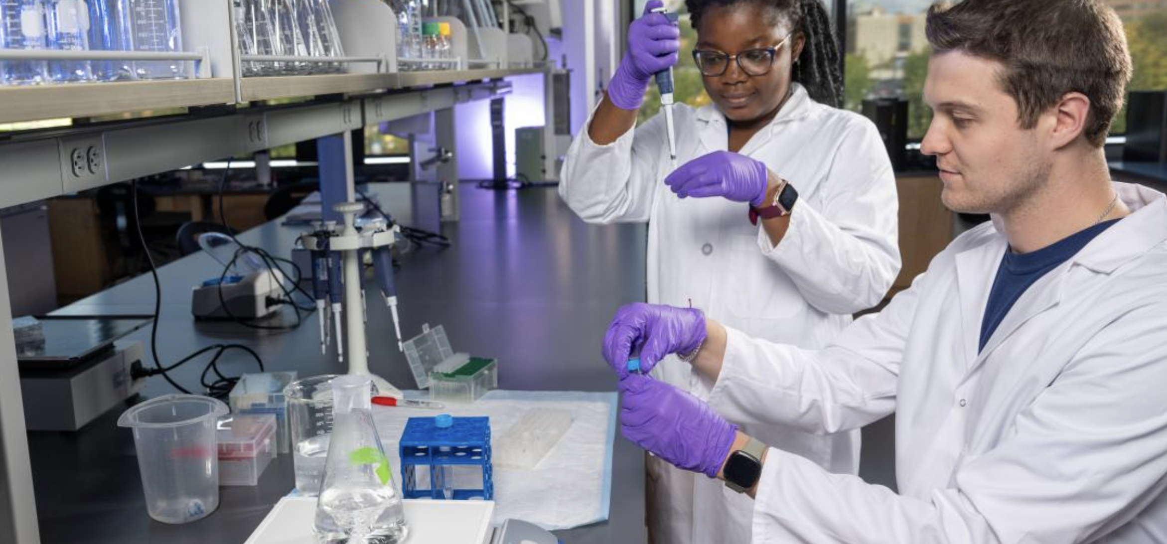 Two Students measuring with pipettes